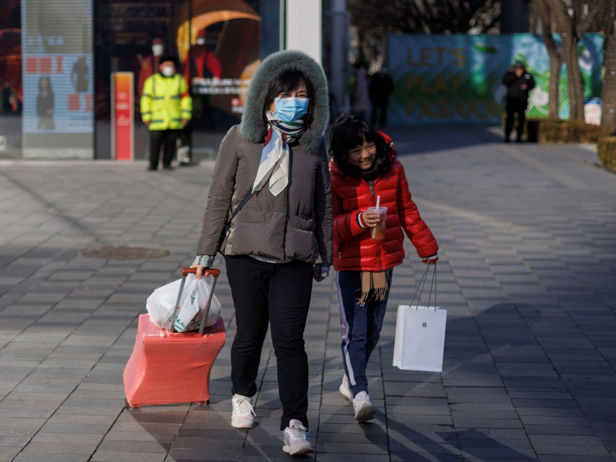 Foto: Una mujer y un niño pasean por un distrito comercial de Pekín. (Reuters/Thomas Peter)