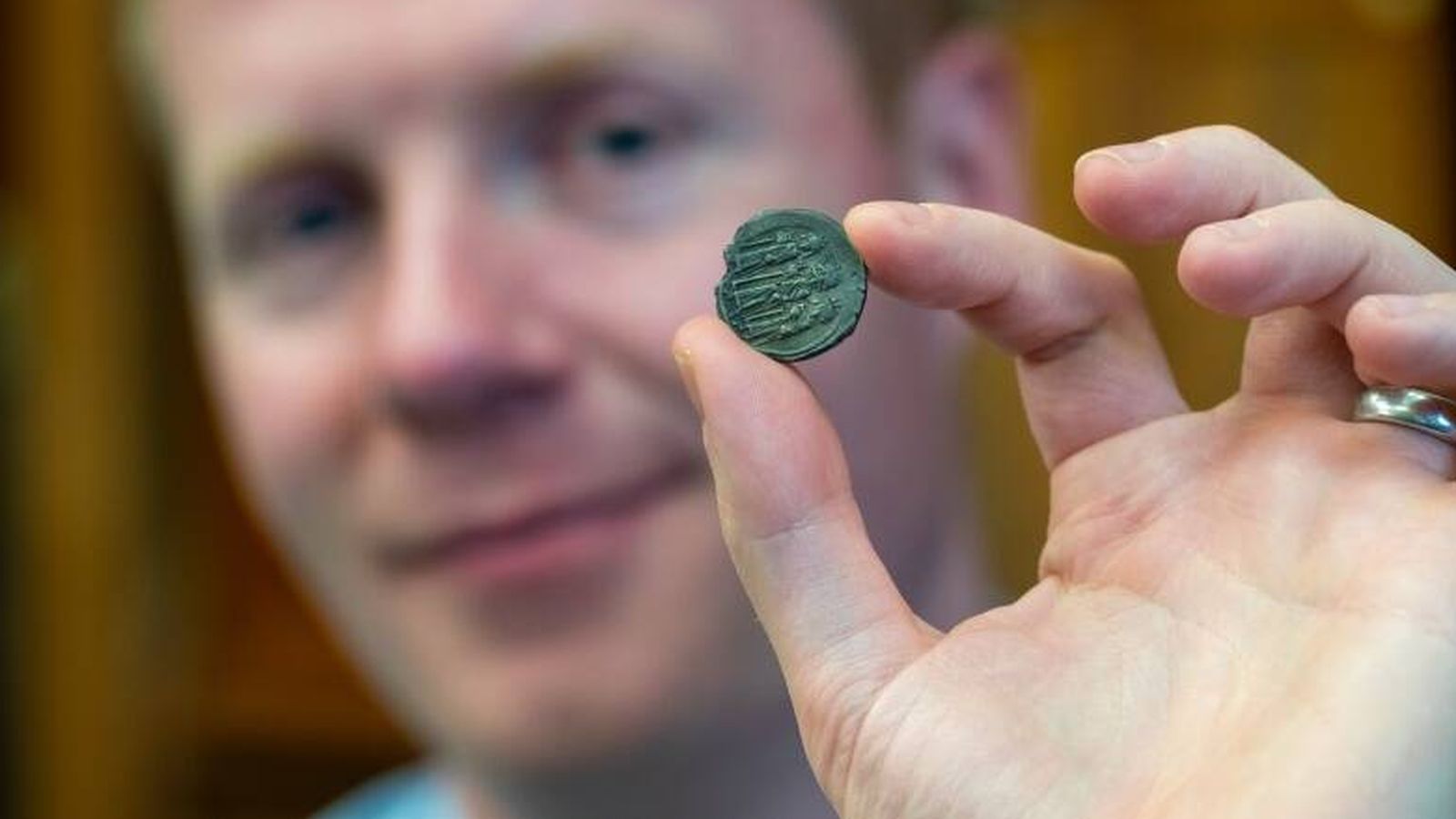 El profesor Rory Naismith cogiendo una moneda.