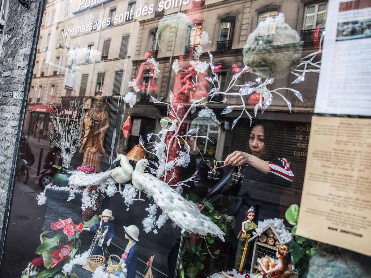 Foto: Una mujer prepara el escaparate de una tienda en París. (EFE)
