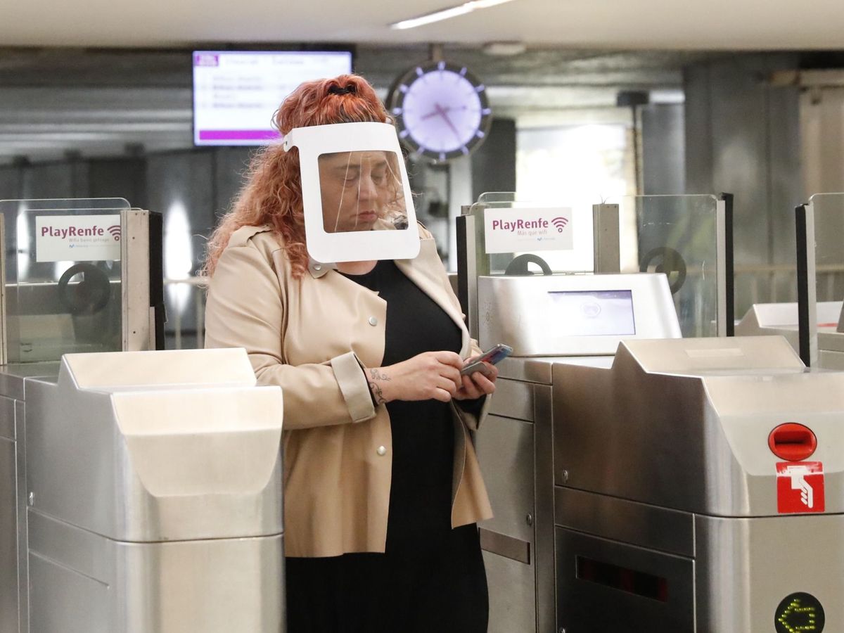 Foto: Una mujer protegida con una pantalla individual sale de la estación de Cercanías de Renfe en Bilbao. (EFE)