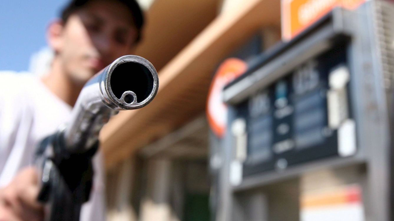 Foto: Un hombre sostiene la manguera de un surtidor en una gasolinera. (EFE)