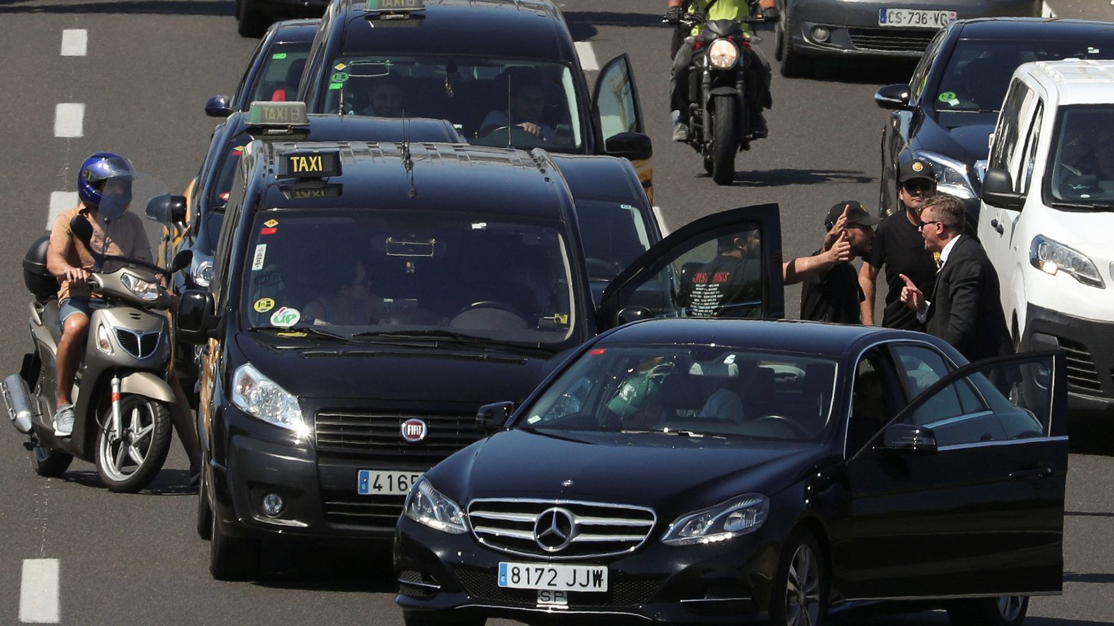 Foto: Unos taxistas discuten en plena calle con el conductor de una VTC en Barcelona. (Reuters)