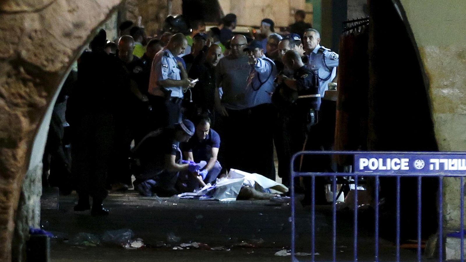 Foto: Personal de seguridad israelí junto al cadáver de un palestino abatido tras acuchillar a dos israelíes en la Ciudad Vieja de Jerusalén, el 3 de octubre de 2015 (Reuters).