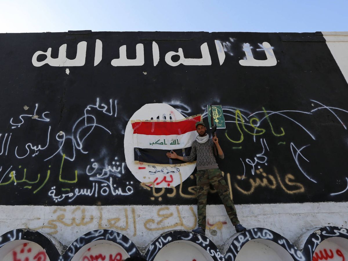 Foto: Un miliciano del Estado Islámico, ante una bandera de ISIS en Al-Alam. (Reuters)