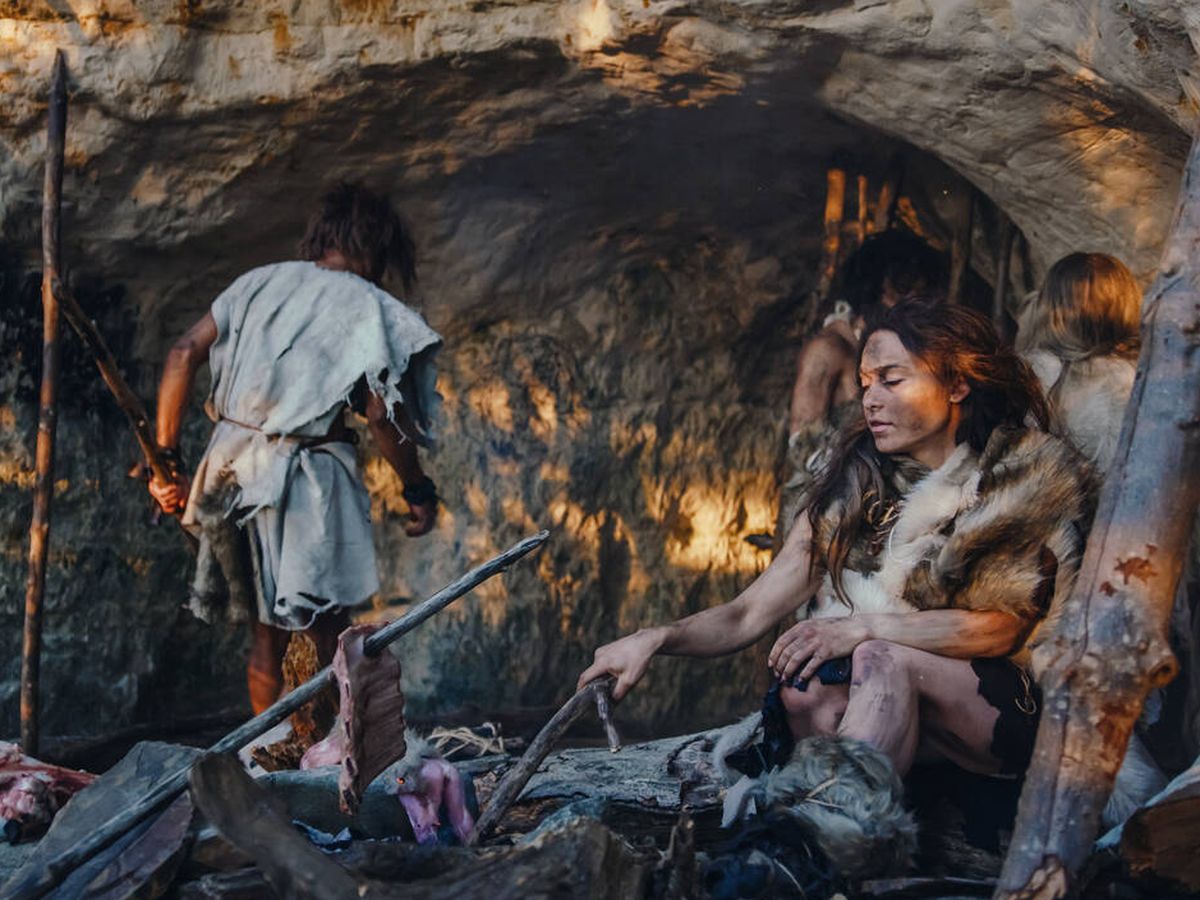 Foto: Familia de neandertales preparando comida en una cueva. (iStock)