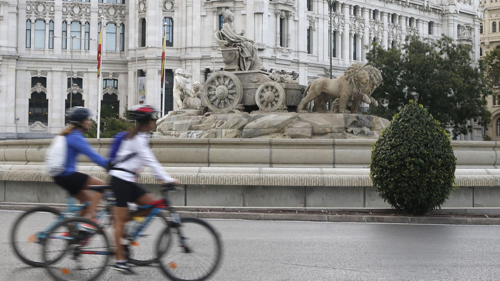 Foto: Dos ciclistas, a su paso por la fuente de Cibeles en Madrid. (EFE)
