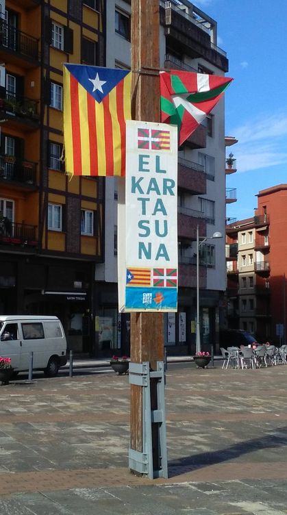Un poste con la estelada y la ikurriña junto a la palabra 'solidaridad' en euskera en una céntrica plaza en Hernani. (E. C.)