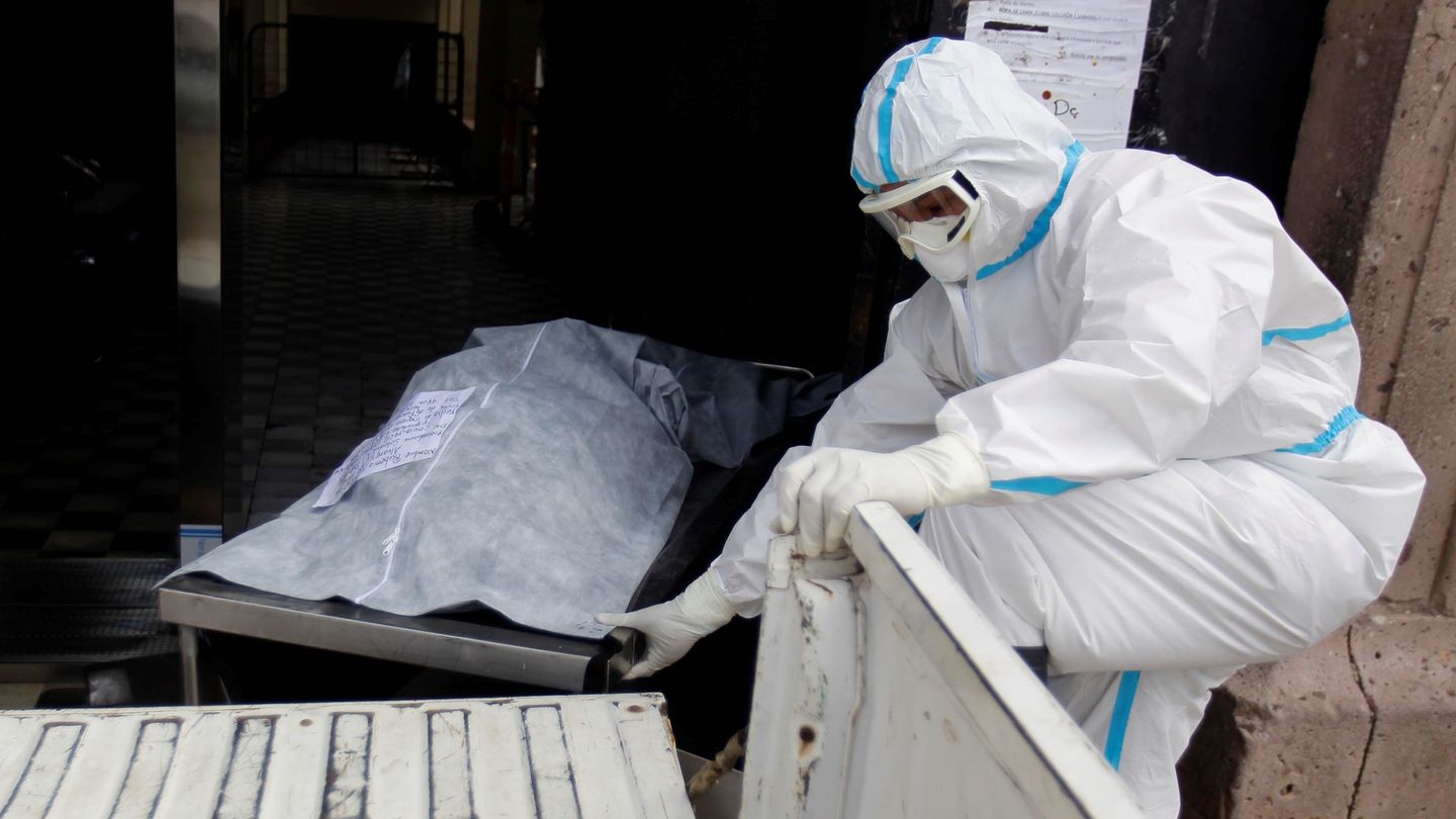 Un trabajador transporta el cuerpo de una persona fallecida por covid-19 en el Hospital San Felipe, en Tegucigalpa (Honduras). (EFE)