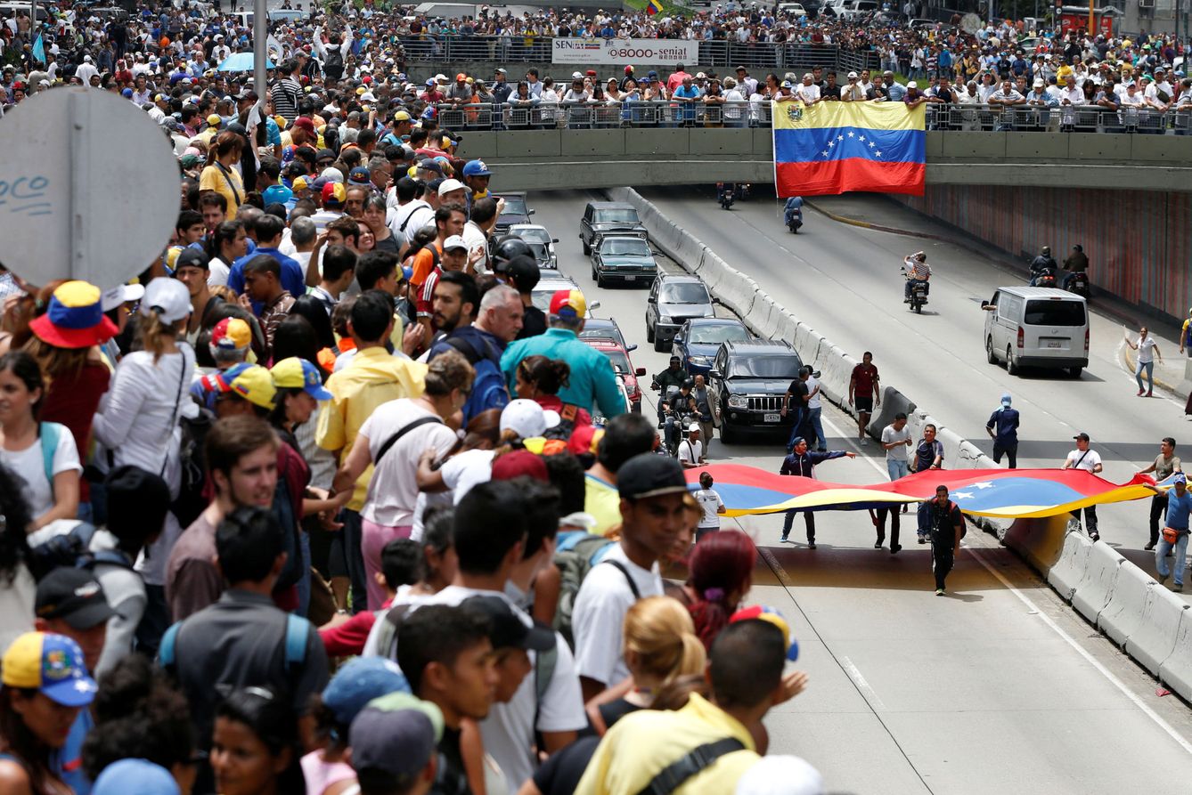 Partidarios de la oposición despliegan banderas venezolanas en Caracas. (Reuters)