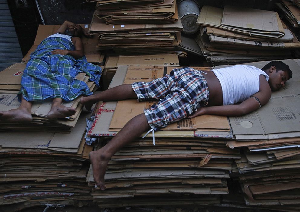 Foto: Trabajadores duermen sobre montaña de cartones en Mombai. (Reuters)