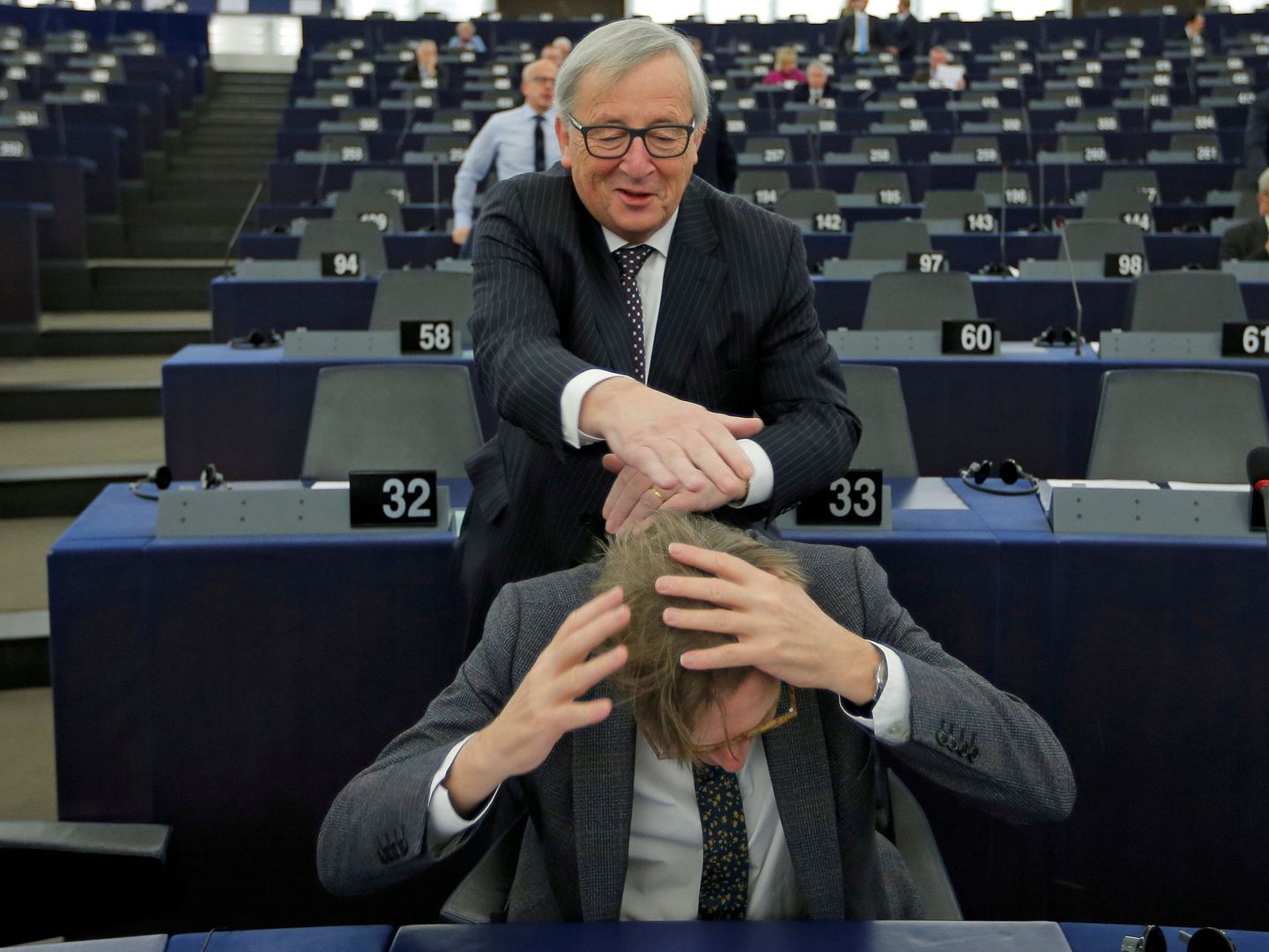 Jean-Claude Juncker bromea con el liberal Guy Verhofstadt en el Parlamento Europeo. (Reuters)