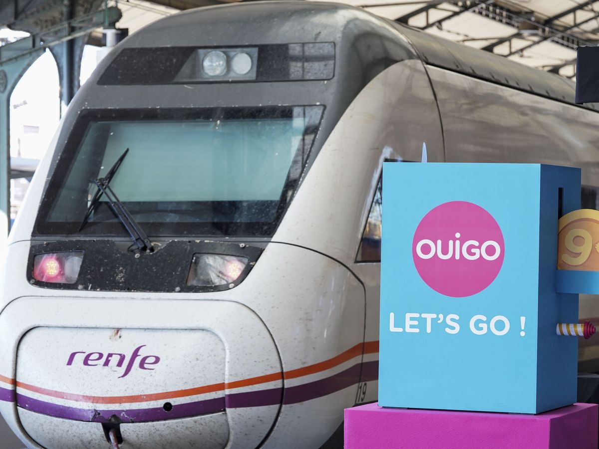 Foto: Un tren de Renfe pasa junto a un cartel publicitario de Ouigo, esta mañana en Valladolid, día en el que la compañía francesa ha inaugurado el nuevo trayecto Madrid-Segovia-Valladolid. (EFE/Nacho Gallego)