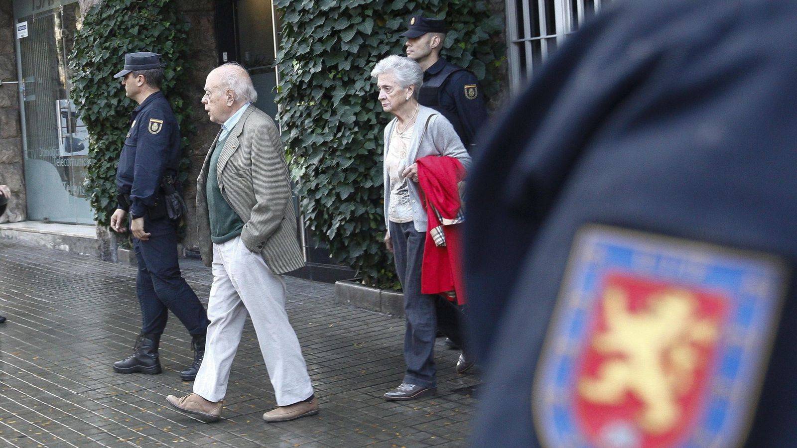 Foto:  El expresidente de la Generalitat, Jordi Pujol, y su esposa, Marta Ferrusola, salen de su domicilio, durante el registro de la UDEF. (EFE)