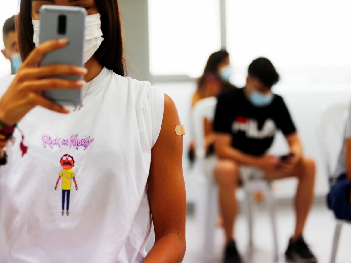 Foto: Una adolescente se hace una foto tras vacunarse. (EFE/Manuel Lorenzo)