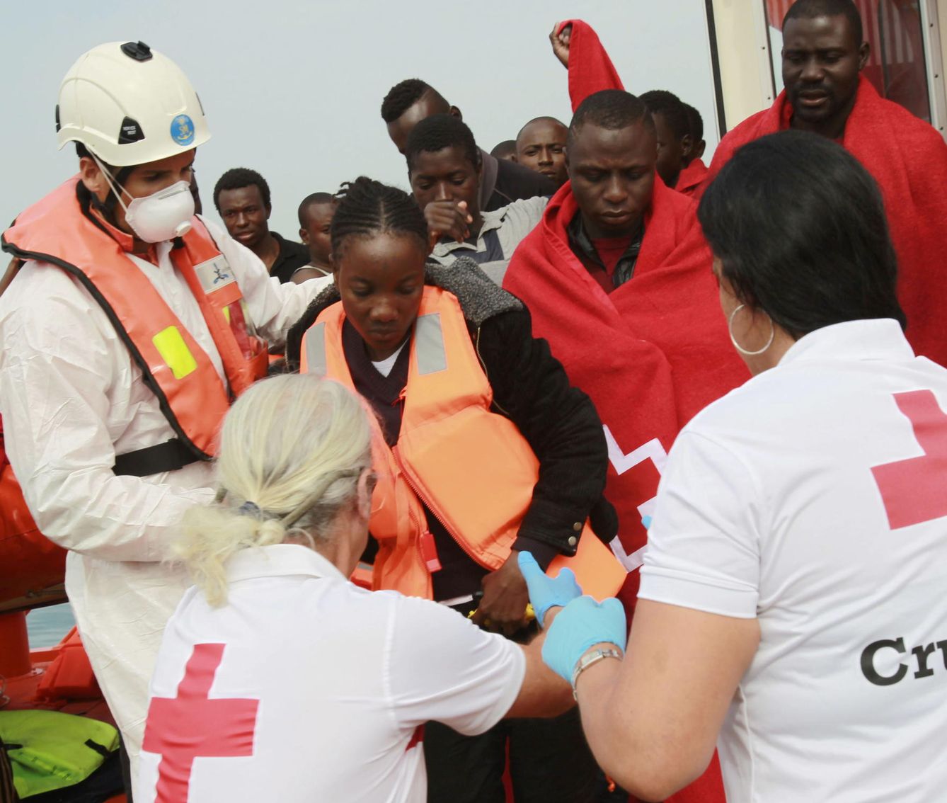 Empleados de Cruz Roja ayudan a desembarcar a inmigrantes subsaharianos. (EFE)