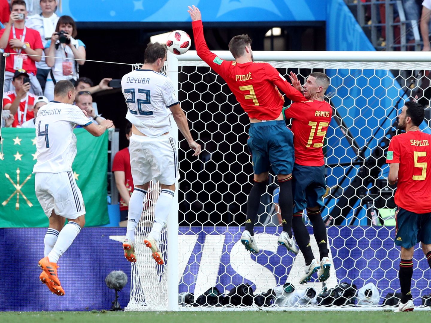 Piqué no quería, pero cometió penalti. Su brazo extendido taponó el remate de Dzyuba. (Reuters)