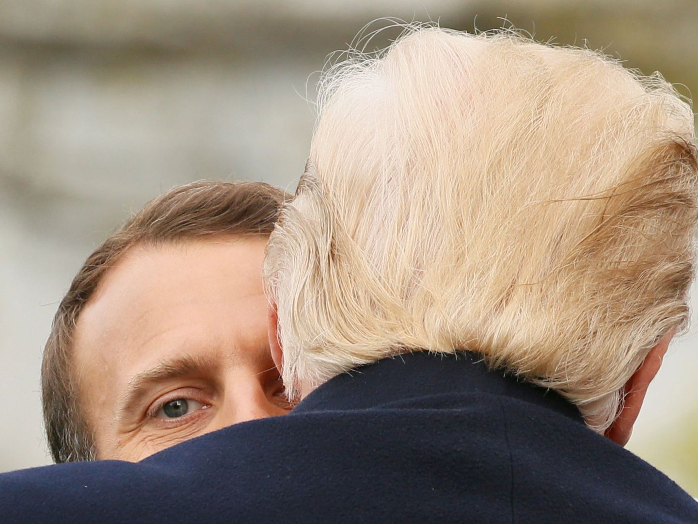 Macron mira por encima del hombro de Trump mientras este le abraza, durante la ceremonia de bienvenida del presidente francés en la Casa Blanca, el 24 de abril de 2018. (Reuters)