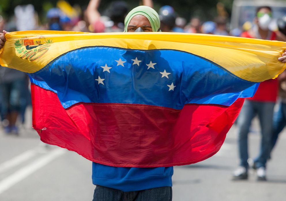 Foto: Un opositor al gobierno del presidente Nicolás Maduro sostiene una bandera de Venezuela durante una manifestación. (EFE)