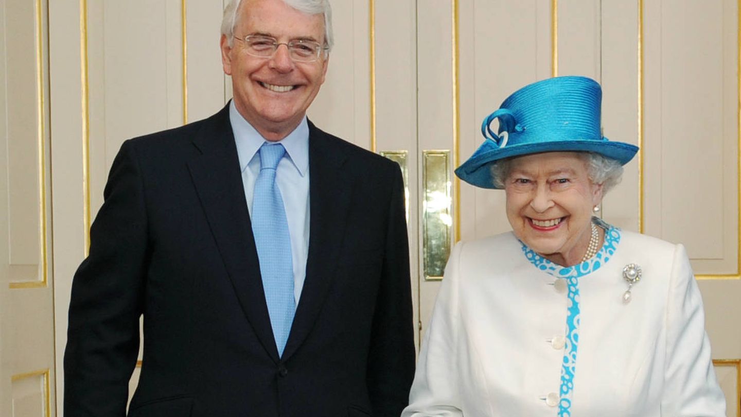 John Major, sonriente junto a la reina Isabel II. 
