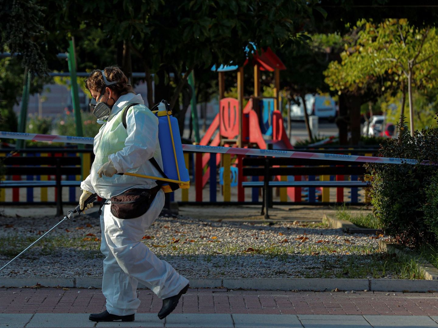 Una trabajadora municipal desinfecta las proximidades un parque infantil clausurado en la localidad madrileña de Alcobendas. (EFE)
