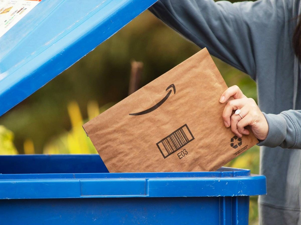 Foto: Una persona tira un sobre de Amazon en un contenedor. (Amazon)