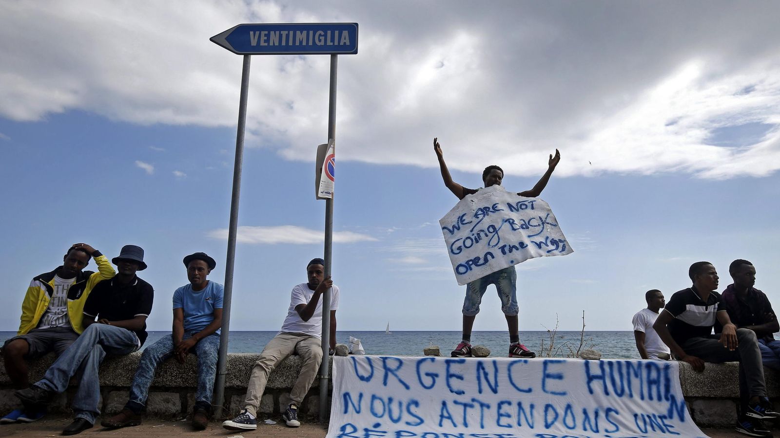 Foto: Varios inmigrantes esperan en la frontera ítalo-francesa cerca de Menton, Francia, el pasado lunes (EFE)