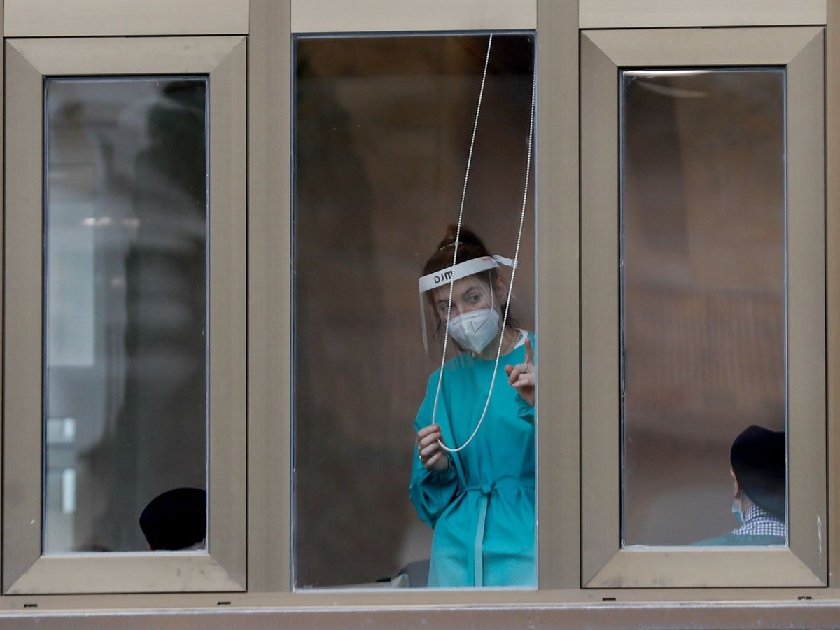Foto: Una trabajadora de una residencia del País Vasco se asoma a una de las ventanas del centro. (EFE)