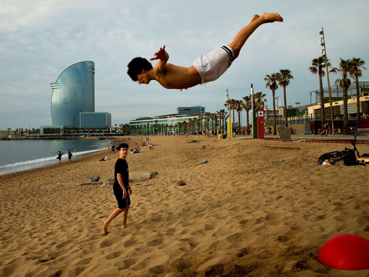 Foto:  Unos jóvenes practican deporte en la playa de la Barceloneta, este lunes 