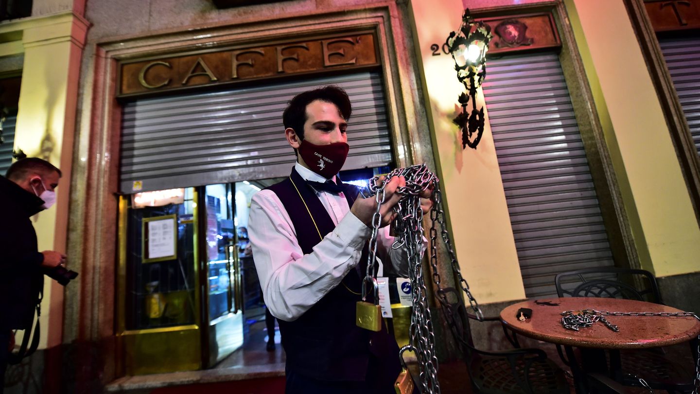 Un camarero cierra un bar por las restricciones contra el coronavirus. (Reuters)