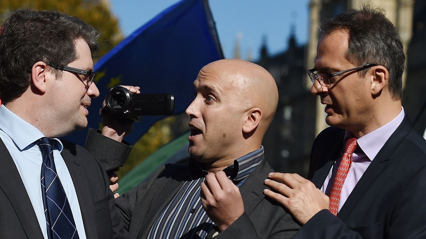Un hombre con una videocámara irrumpe en la rueda de prensa dada por Eliot Higgins, fundador del portal de investigación Bellingcat, a las puertas del Parlamento en Londres (Reino Unido) en octubre de 2018. (EFE)