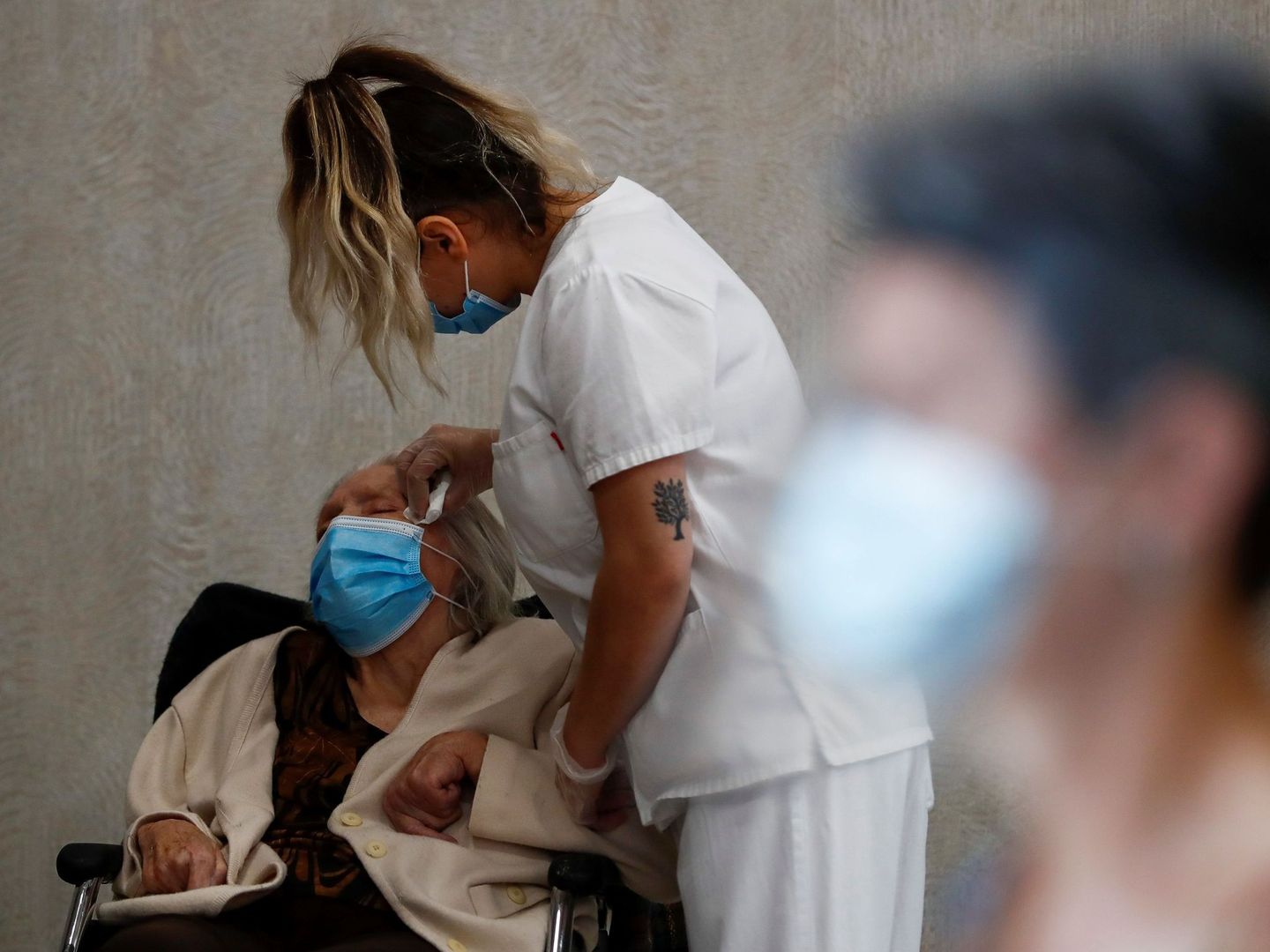 Una enfermera asiste a una anciana en una residencia de Madrid. (EFE)