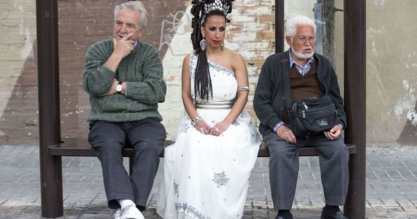 Foto: Tres personas esperan el autobús en el barrio de El Cabanyal, en Valencia. (EFE)