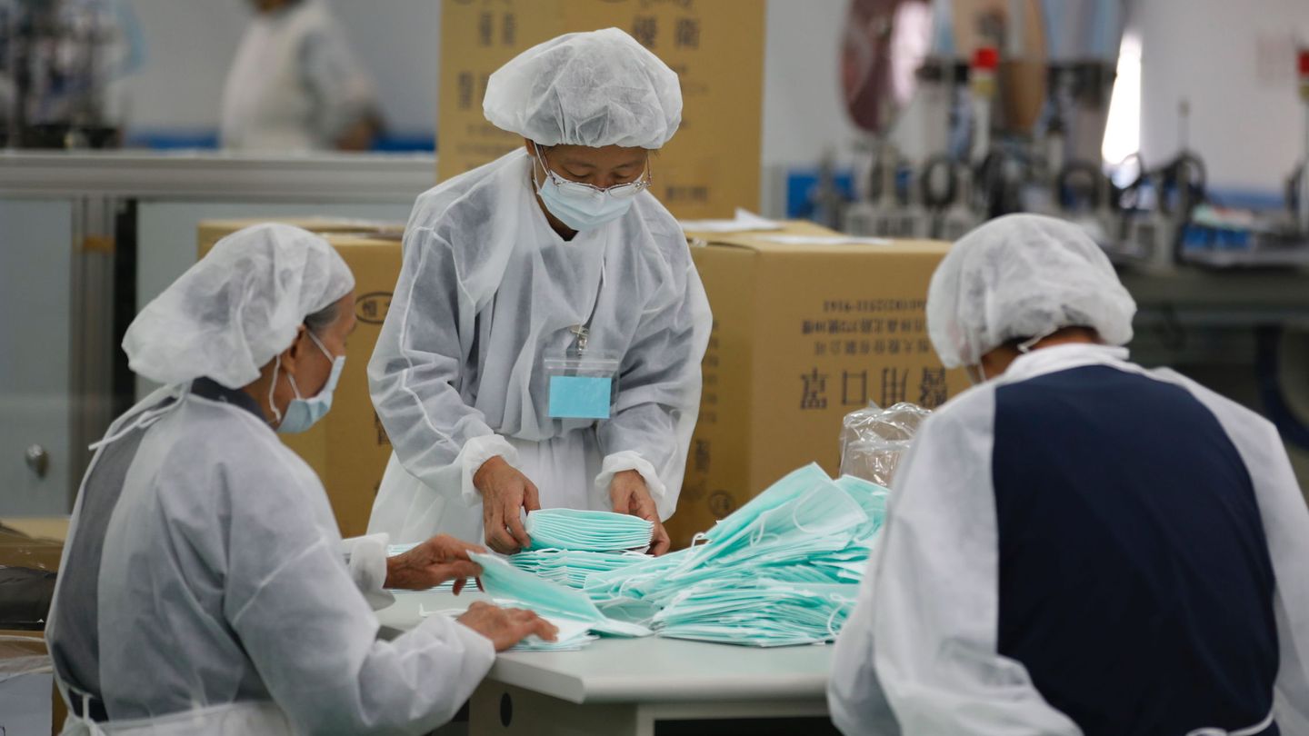 Voluntarios y militares trabajan en la fabricación de mascarillas en una fábrica de Taiwán a la que pidió ayuda el gobierno. (EFE)