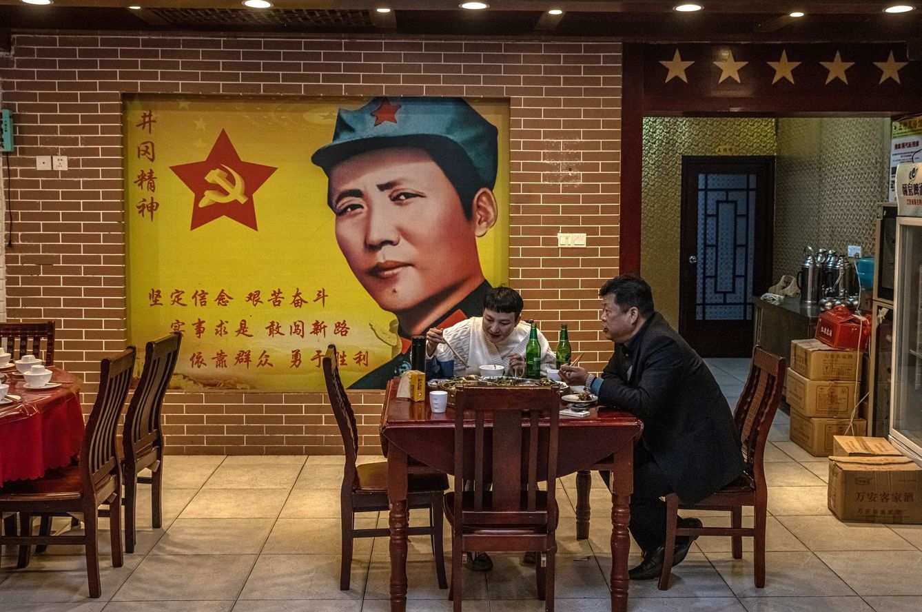 Gente comiendo en un restaurante bajo la imagen de Mao Tse-tung en la provincia china de Jiangxi (EFE)