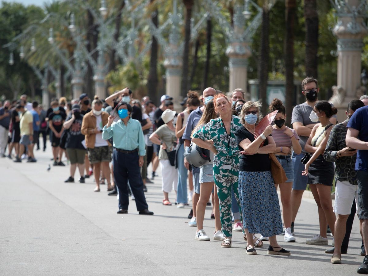 Foto: Numerosas personas esperan para vacunarse en un punto móvil instalado en Arco de Triunfo, en Barcelona. (EFE) 