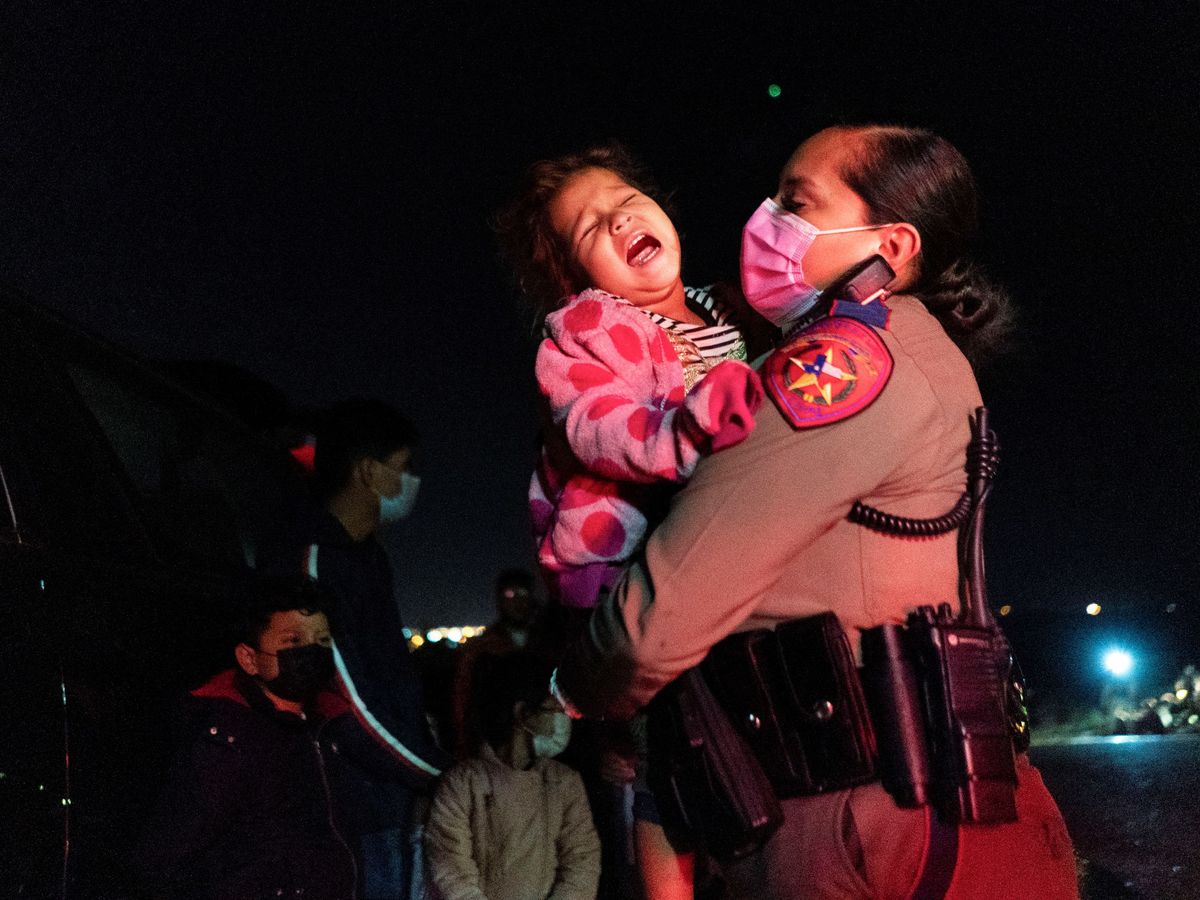 Foto: Una agente trata de consolar a una niña migrante que cruzó sin acompañantes la frontera de México con Estados Unidos. (Reuters)