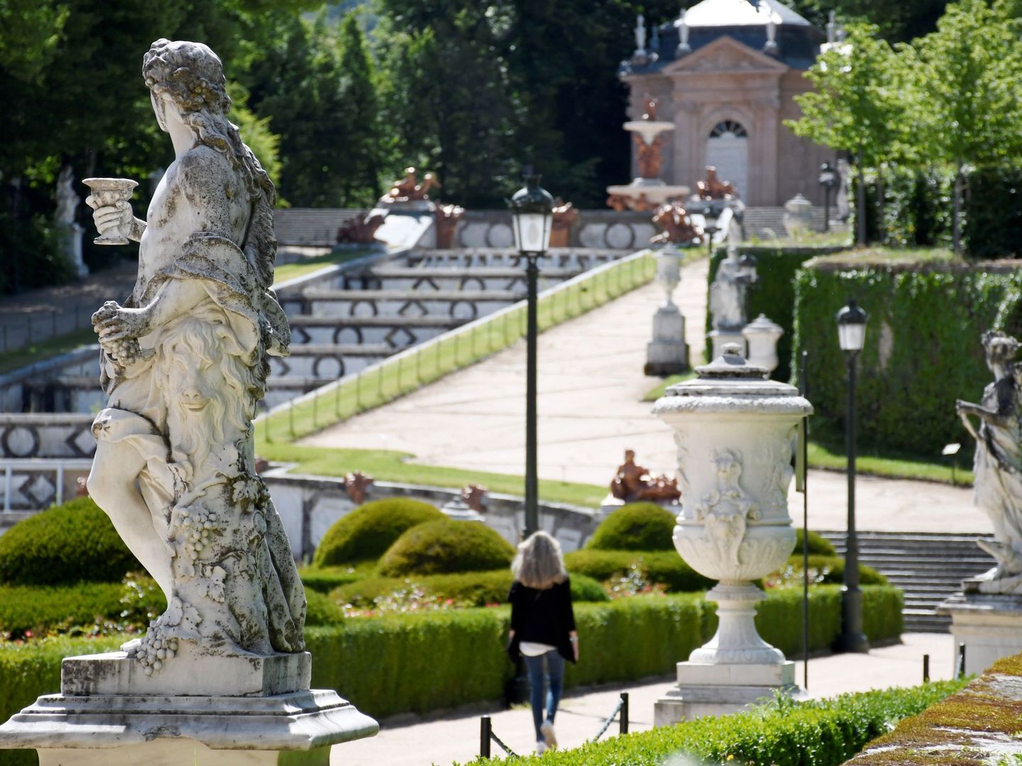 Una turista pasea por los jardines del Palacio Real de La Granja de San Ildefonso. (EFE/Pablo Martín)