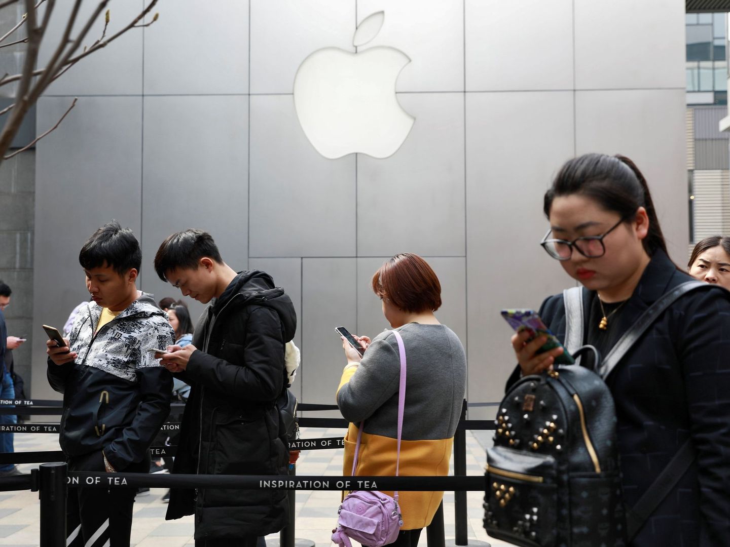 Varias personas hacen cola a las puertas de una tienda Apple en Pekín, el 23 de marzo de 2018. (EFE)