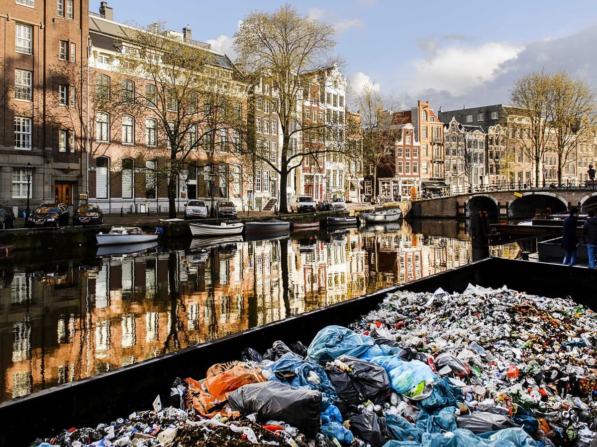 Foto: Los servicios de limpieza recogen en contenedores flotantes la basura acumulada con motivo de los festejos por el Día del Rey, en Amsterdam. (EFE /Remko De Waal)