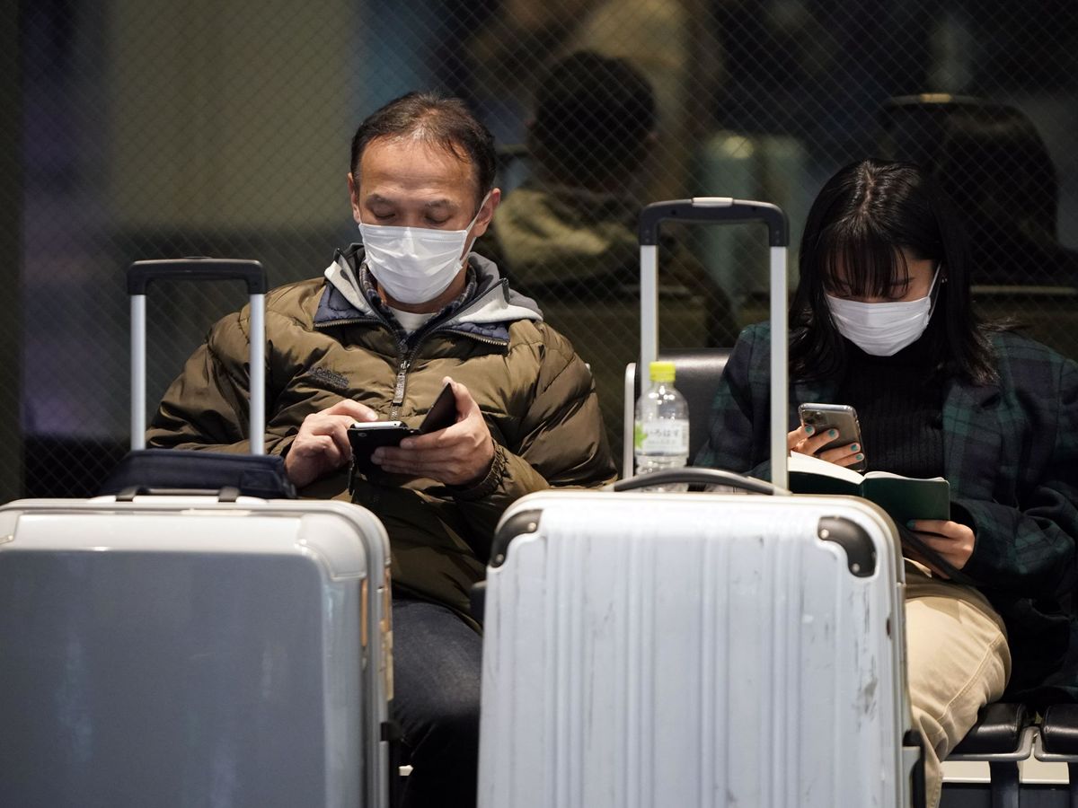 Foto: Dos viajeros, protegidos frente al virus de Wuhan. (Reuters)
