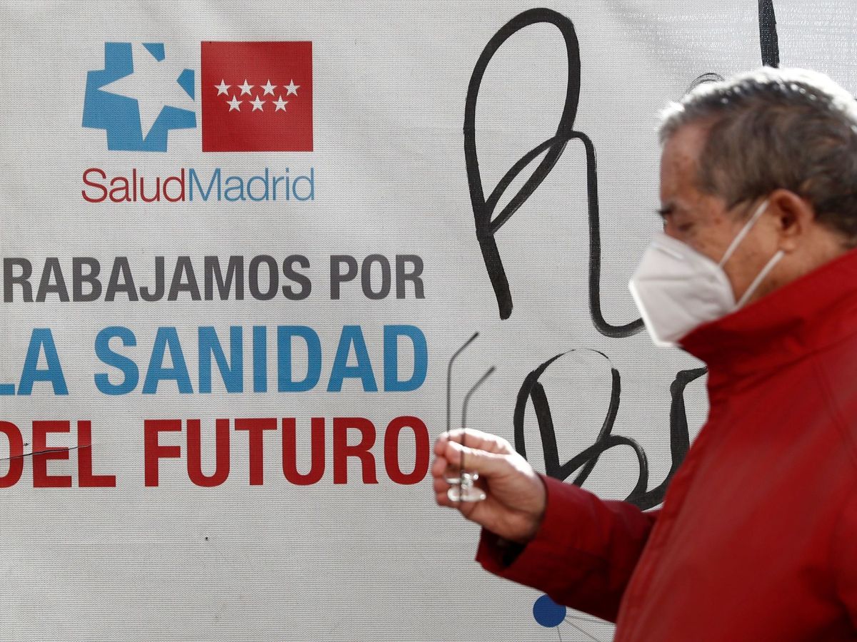 Foto: Un hombre pasea frente a un cartel de la Comunidad de Madrid. (EFE)