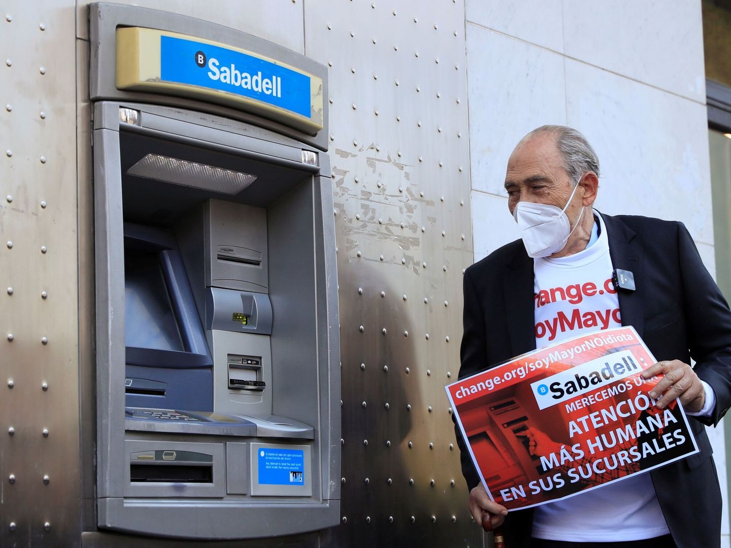 Carlos San Juan posa junto a un cajero automático tras registrar las 600.000 firmas en el Ministerio Economía. (EFE)