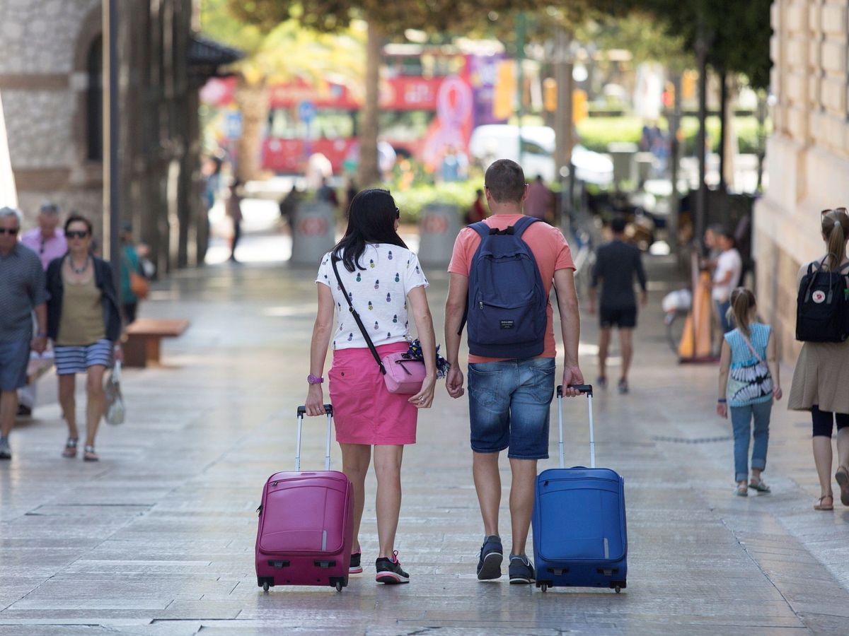 Foto: Una pareja de turistas camina con sus maletas. (Foto: EFE)