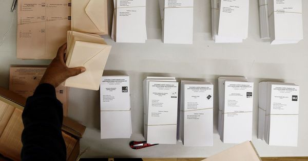 Foto: Una persona coloca en la mesa de un colegio electoral de Pamplona las papeletas. (EFE)