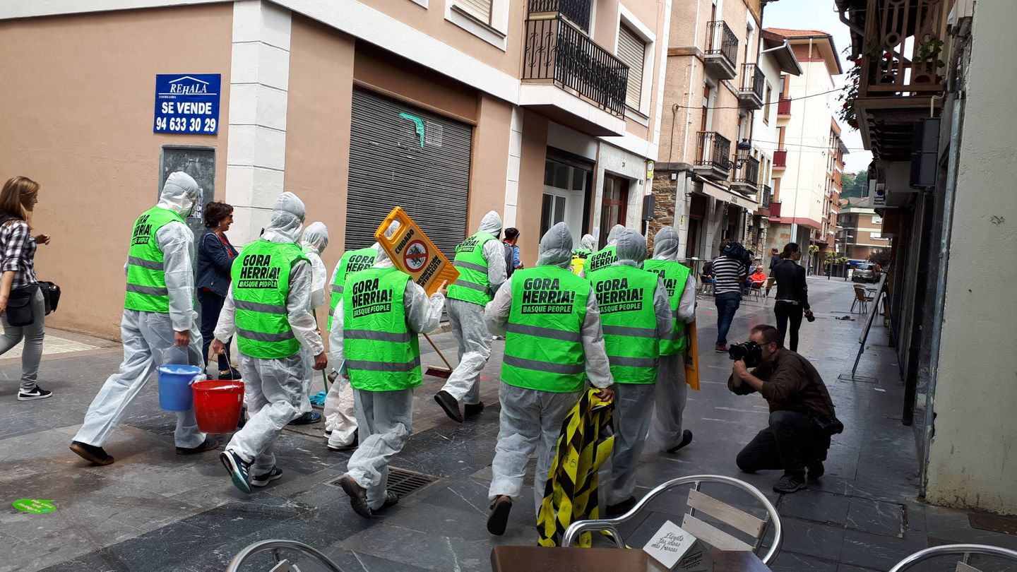 Vecinos simulan una brigada de 'desinfección antifascista' para limpiar las calles de Miravalles tras el paso de Ciudadanos, (J. M. A.)
