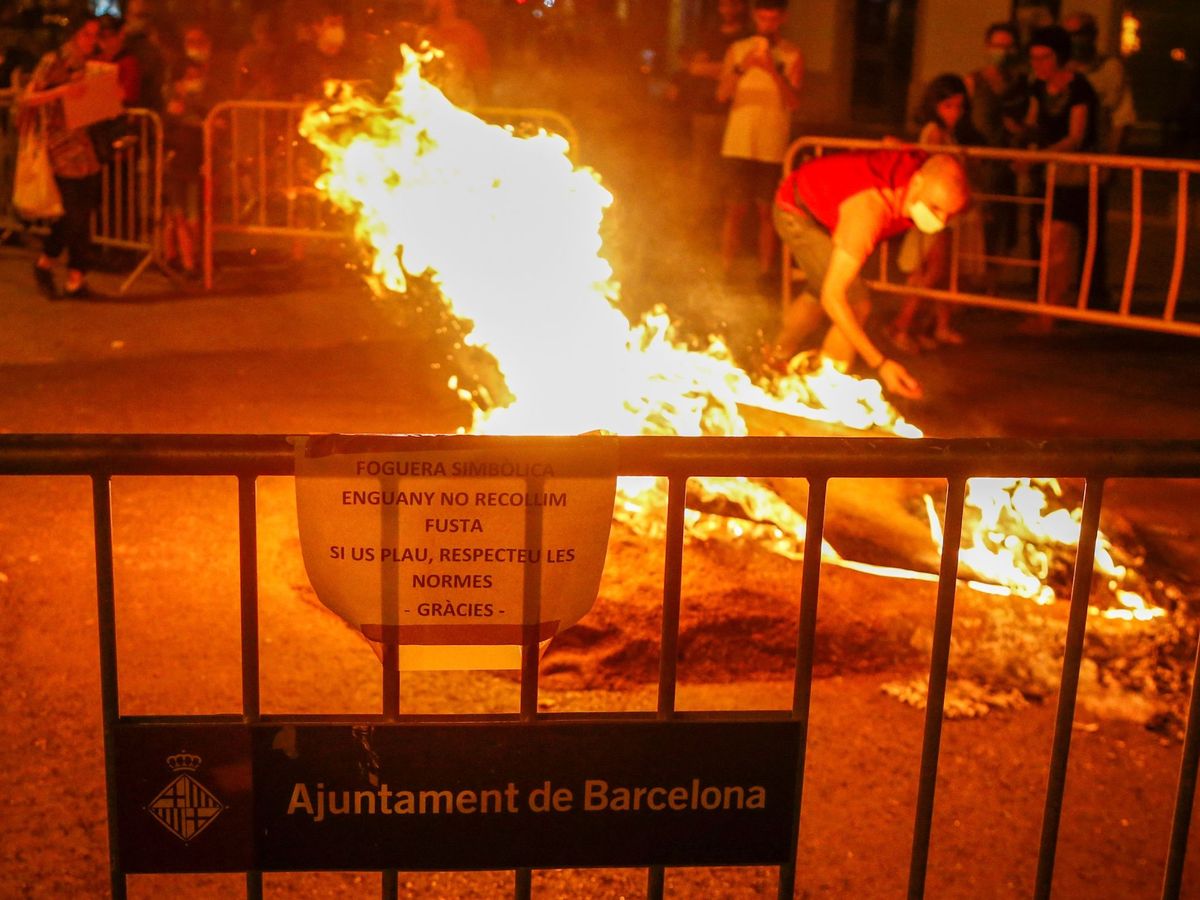 Foto: Unos vecinos del barrio de Sant Antoni de Barcelona hacen arder una hoguera simbólica en la calle Entença con la Av Mistral (EFE)