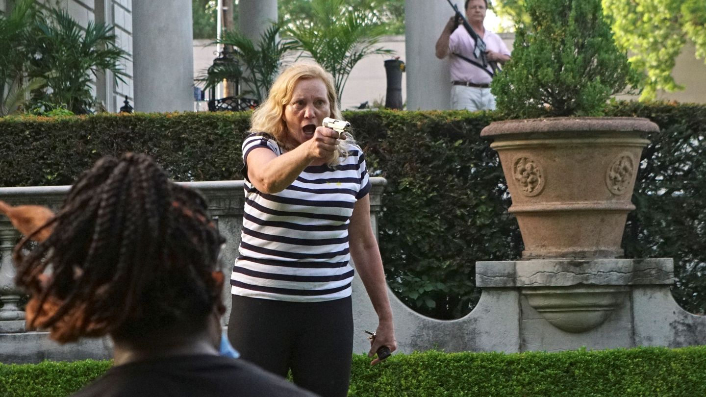La mujer, apuntando con una pistola a los manifestantes que pasaban cerca de su mansión. (Reuters)