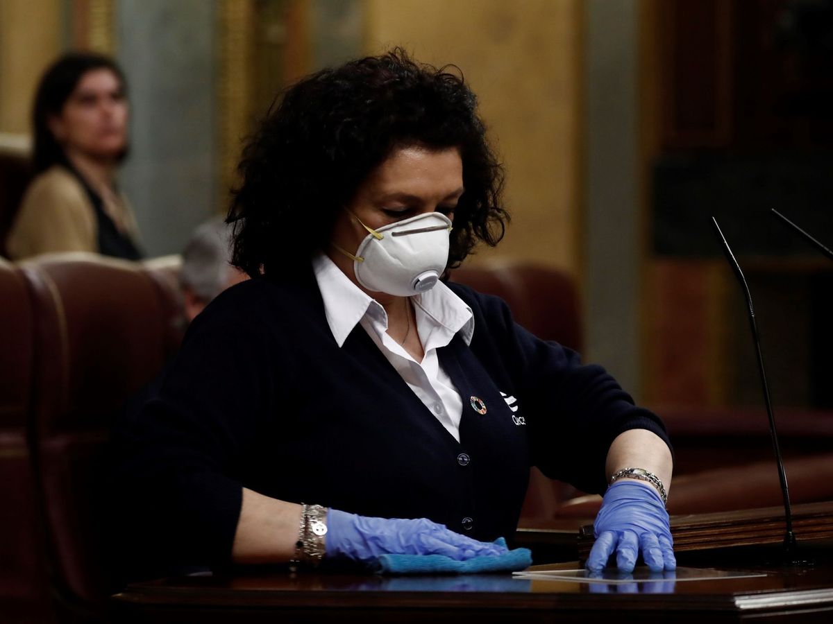 Foto: Valentina, que trabaja como ujier en el Congreso, desinfecta el atril. (EFE)