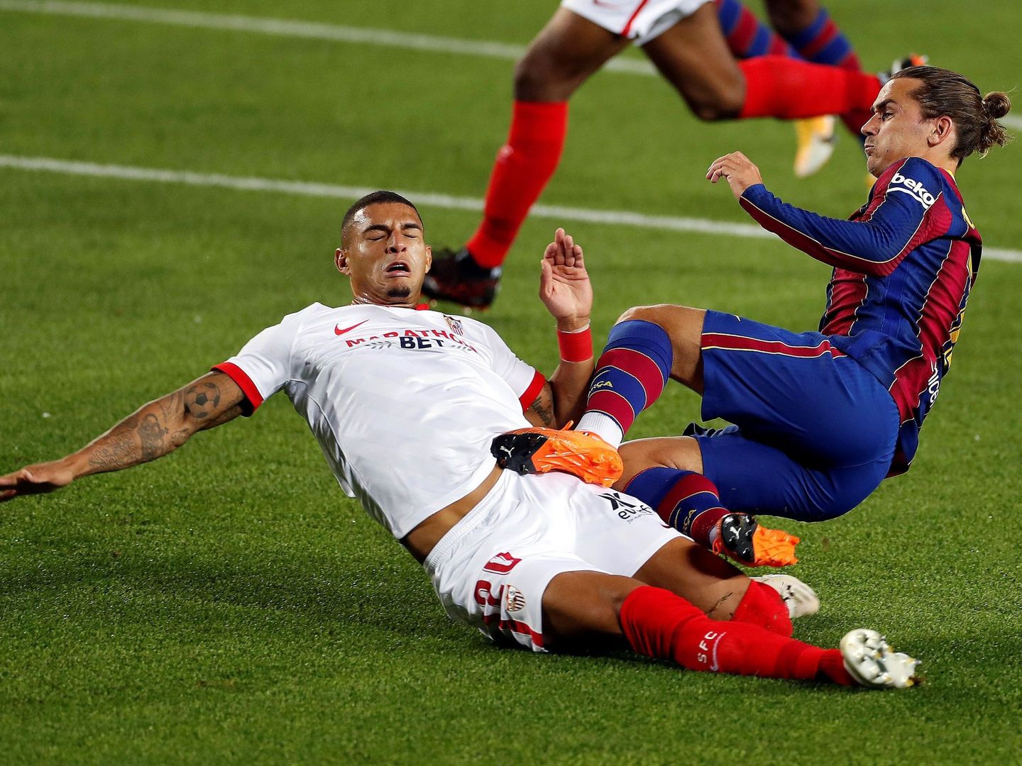 Griezmann y Diego Carlos en el partido entre el Barcelona y el Sevilla. (Efe)