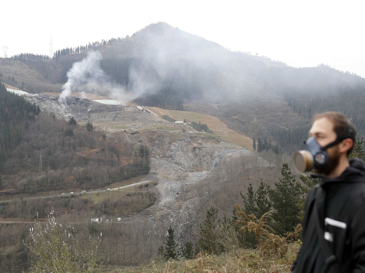 Foto: Un reportero de televisión protegido, en la localidad vizcaína de Ermua, con el fuego de fondo. (EFE)